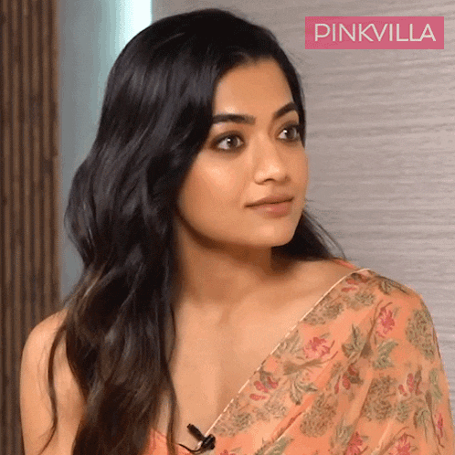 a close up of a woman wearing a floral saree with pinkvilla written on the bottom
