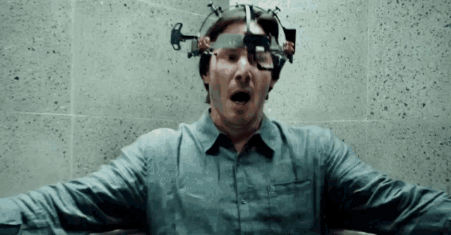 a man is sitting in a bathtub with a device on his head and his mouth open .