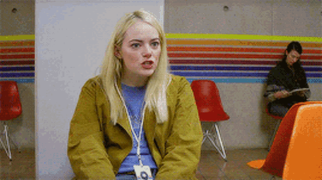 a woman wearing a name tag with the letter o on it sits in a waiting room