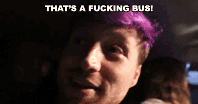 a man with purple hair and the words that 's a fucking bus behind him