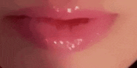 a close up of a woman 's lips with pink lipstick on .