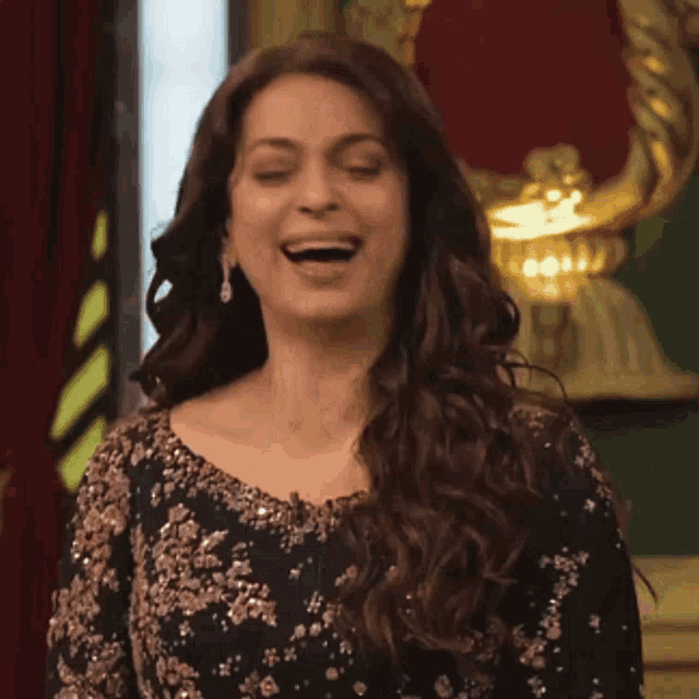 a woman is laughing and clapping her hands in front of a mirror