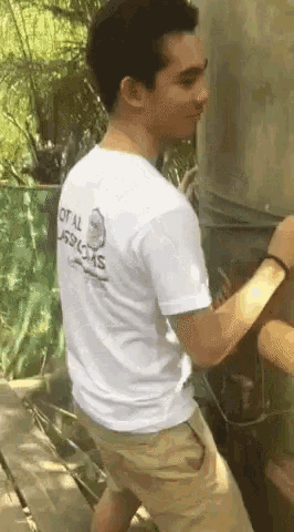 a man wearing a white shirt that says total services on the back
