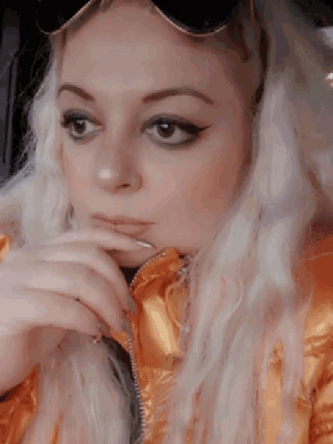 a close up of a woman 's face with her hand on her chin