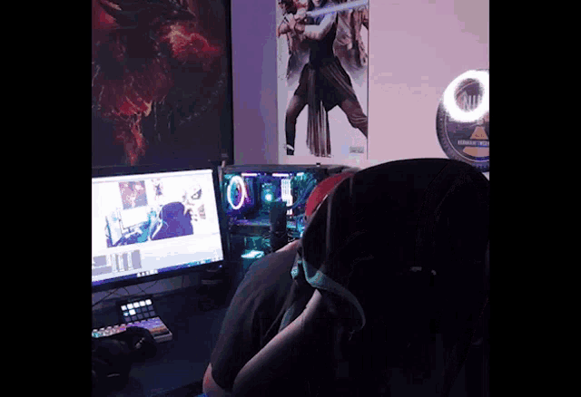 a person sitting in front of a computer with a poster on the wall behind them that says ' empire strikes back '