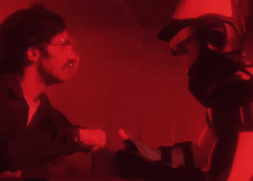 a man and a woman are shaking hands in a red room