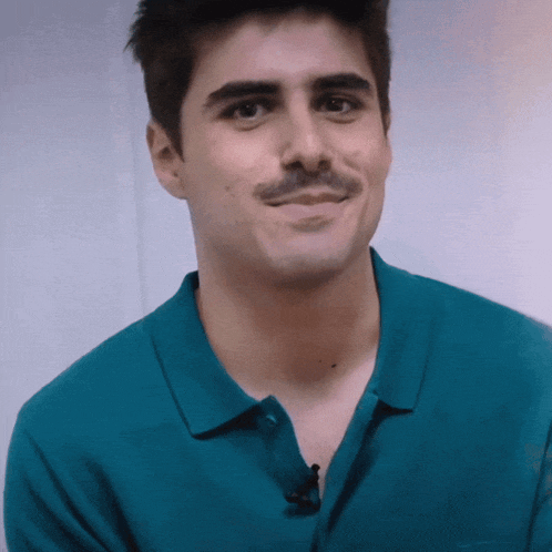 a man with a mustache is wearing a green polo shirt