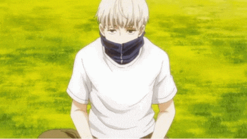 a man wearing a white shirt and a black scarf is sitting in a field .