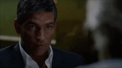 a person is standing behind a wooden table with a blue tie
