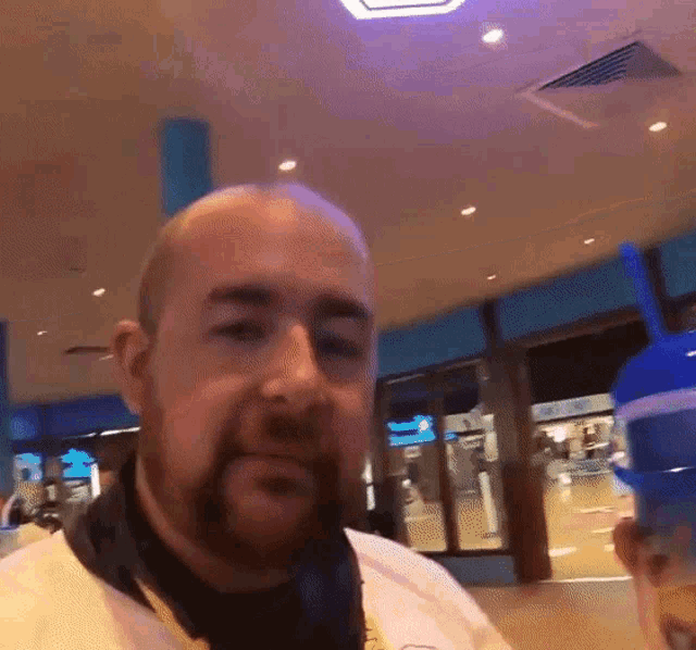 a bald man with a beard is wearing headphones and a white shirt
