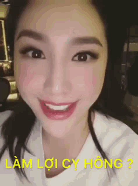 a close up of a woman 's face with the words " làm lợi cụ hong " written in yellow