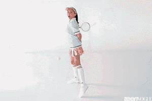 a woman in a tennis outfit is holding a tennis racket and smiling