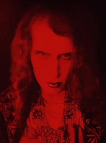 a close up of a woman 's face with a red light behind her