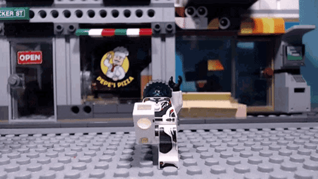 a lego figure is carrying a box in front of a peppy 's pizza shop