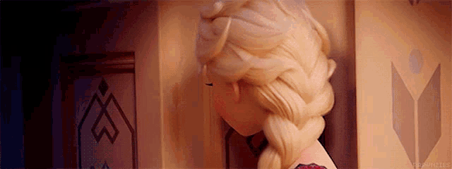 a close up of a doll 's head with a braid and a stained glass window in the background