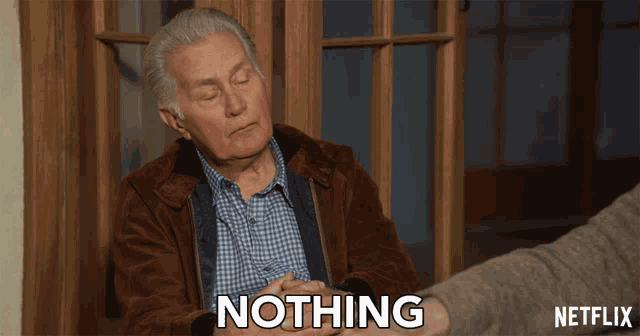 a man in a brown jacket says nothing in front of a netflix sign