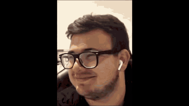 a man with glasses is covering his mouth with his hand