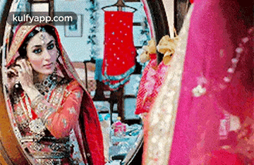 a bride is looking at herself in a mirror .