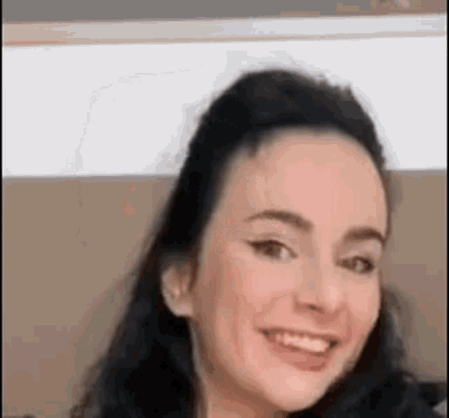 a close up of a woman 's face with a smile on her face .