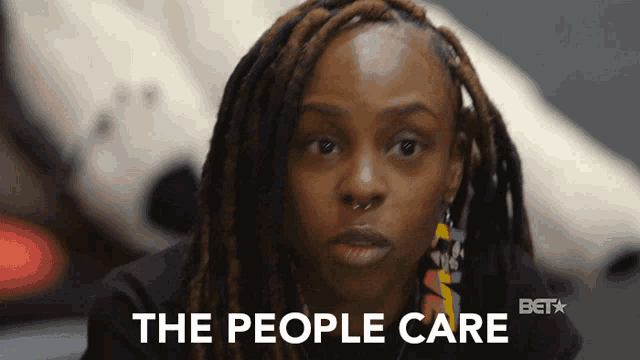 a woman with dreadlocks has the words " the people care " on her face