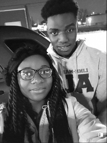 a black and white photo of a boy and a girl with the boy wearing a hoodie that says ia
