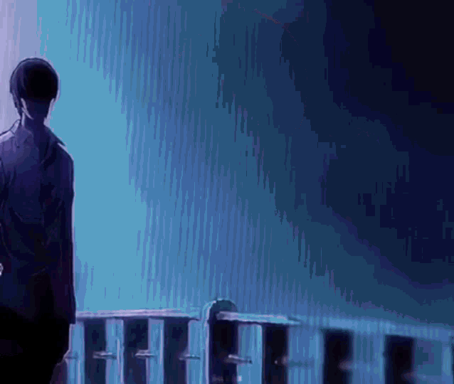 a man is standing on a balcony looking out at the water .