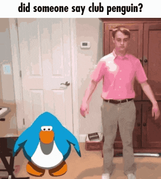 a man in a pink shirt is standing next to a penguin in a room
