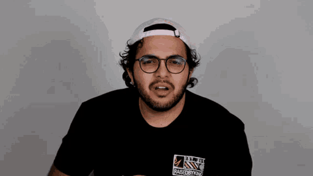 a man wearing glasses and a pink hat says are you fucking serious