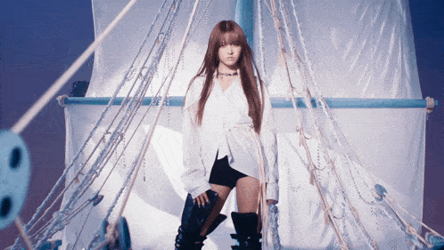 a woman in a white shirt and black shorts is standing in a boat