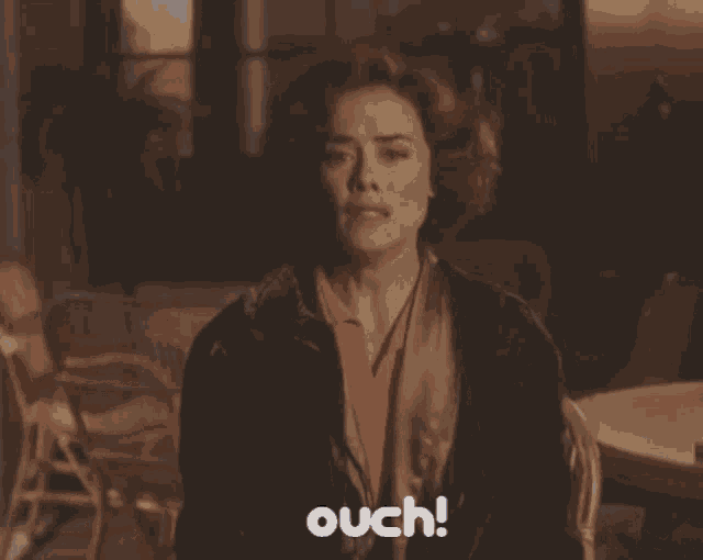 a woman is making a funny face and the word ouch is next to her