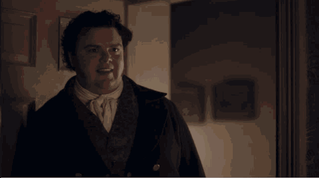 a man in a suit stands in a doorway