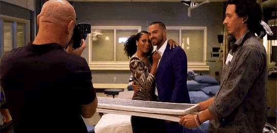 a man is taking a picture of a woman and a man in a hospital room .
