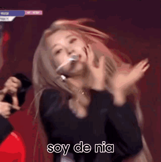 a woman is dancing on a stage with the words soy de mia written on the bottom