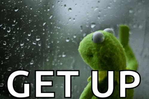 a kermit the frog is looking out a window with the words get up behind him