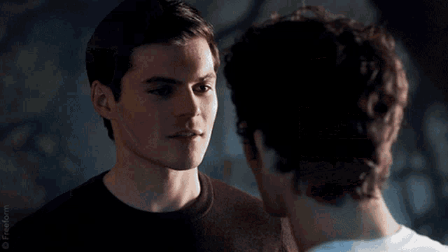 a close up of two men kissing with the words freeform on the bottom right