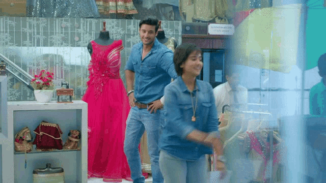 a man and a woman are dancing in front of a store window with a sign that says " no smoking " on it