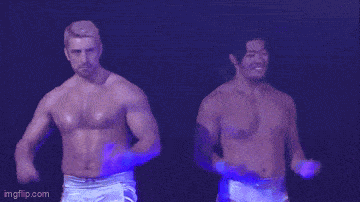 a couple of people standing on a stage with a blue background .