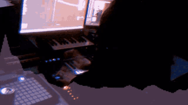 a person is playing a keyboard in front of a computer