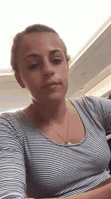a woman wearing a striped shirt is sitting at a table .