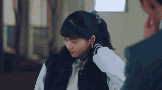 a girl with a ponytail is looking at a man
