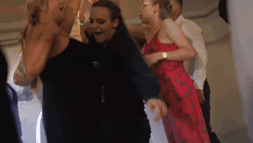 a group of people are dancing together on a dance floor at a wedding reception .
