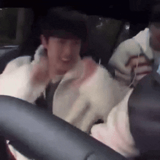 a man is sitting in the back seat of a car with headphones on .