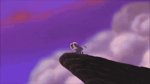 a lion is standing on the edge of a cliff with a purple sky in the background