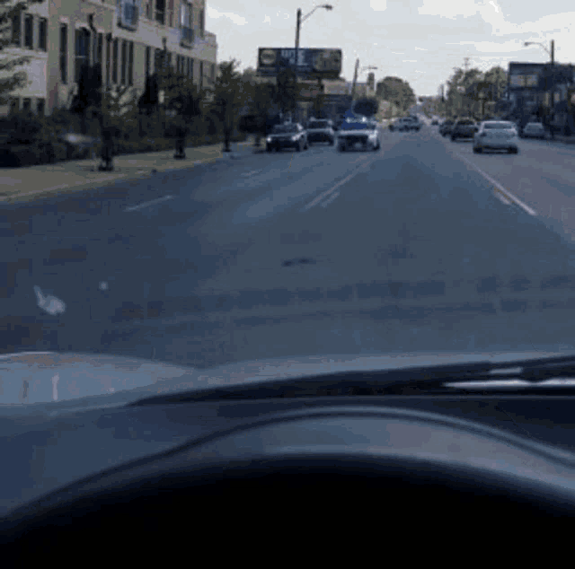 a car is driving down a street with a billboard in the background that says ' nbc ' on it