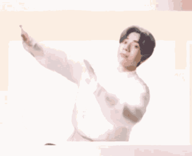 a man in a white shirt is doing a dab with his arm outstretched .