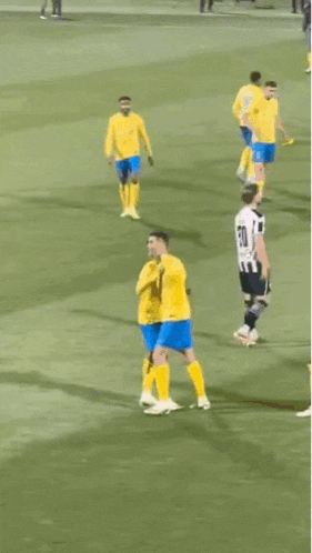 a group of soccer players are on a field with one wearing a yellow jersey with the number 7 on it