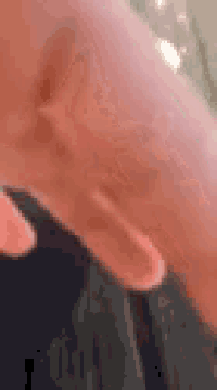 a close up of a person 's hand with a ring on their finger .