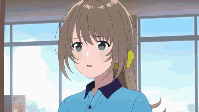 a girl with brown hair and green eyes is wearing a blue shirt and a yellow flower in her hair