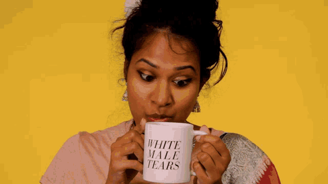 a woman is drinking from a white male tears mug