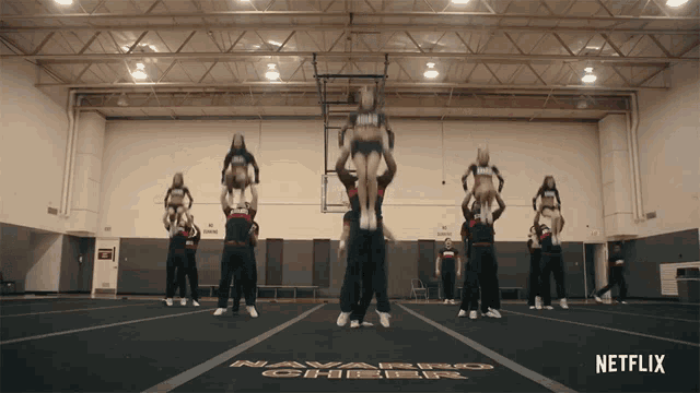 a group of cheerleaders perform in a gym that says navarro cheer